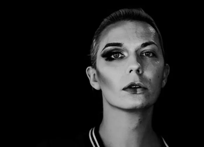 homem trans maquiagem de um lado do rosto