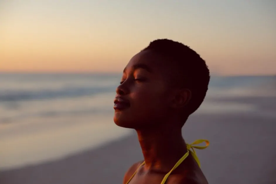 Mulher observa o mar e pensa no sentido da vida